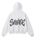 A white zip-up hoodie shown from both the front and back. The front features a small black 'SAVAGE' graphic on the left chest, and the back features a large, stylized black 'SAVAGE' graphic across the center.